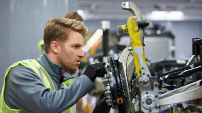 Un employé en tenue de travail exploite une machine.