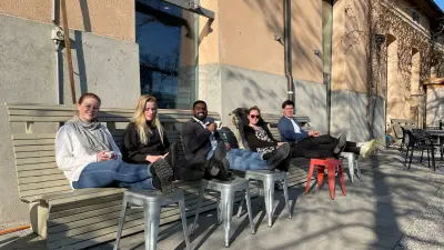 Die Gruppe geniesst draussen an der Sonne mit dem Projekt Host Sephin (in der Mitte) einen wohlverdienten Kaffee. 